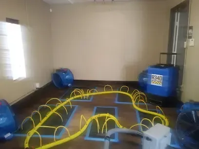 Floor drying mats and air movers working on a wet floor